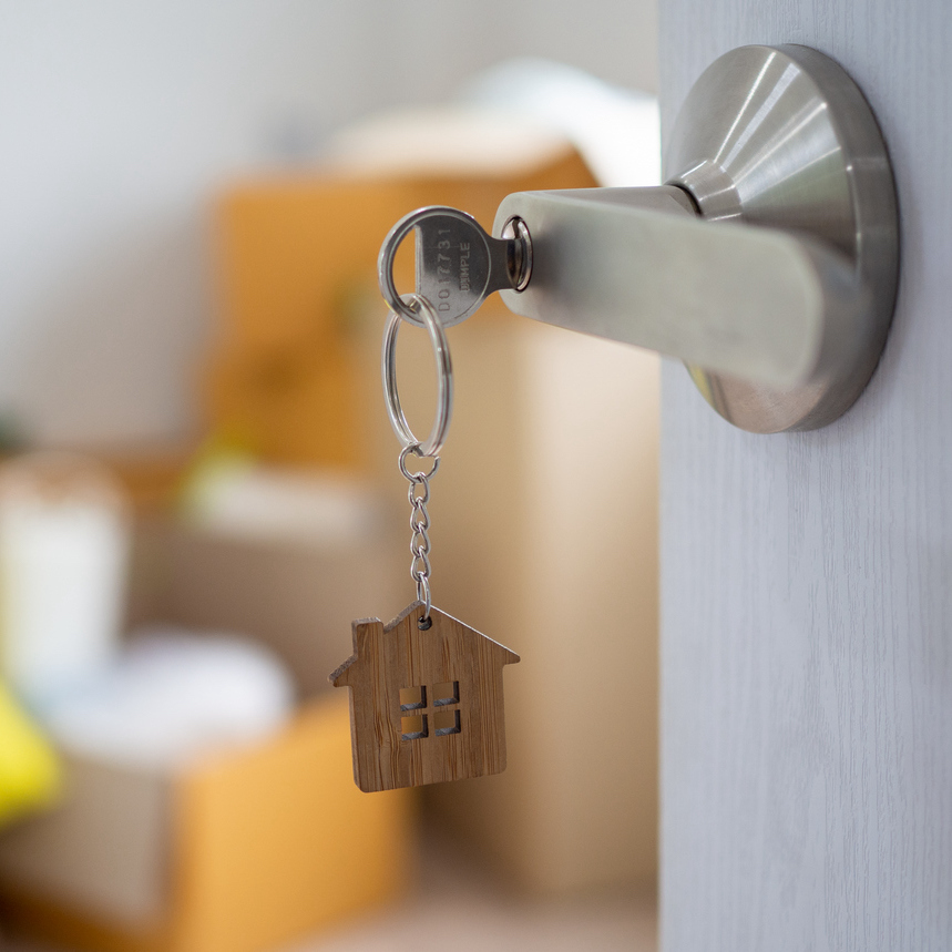 house key unlocking new house is plugged into door